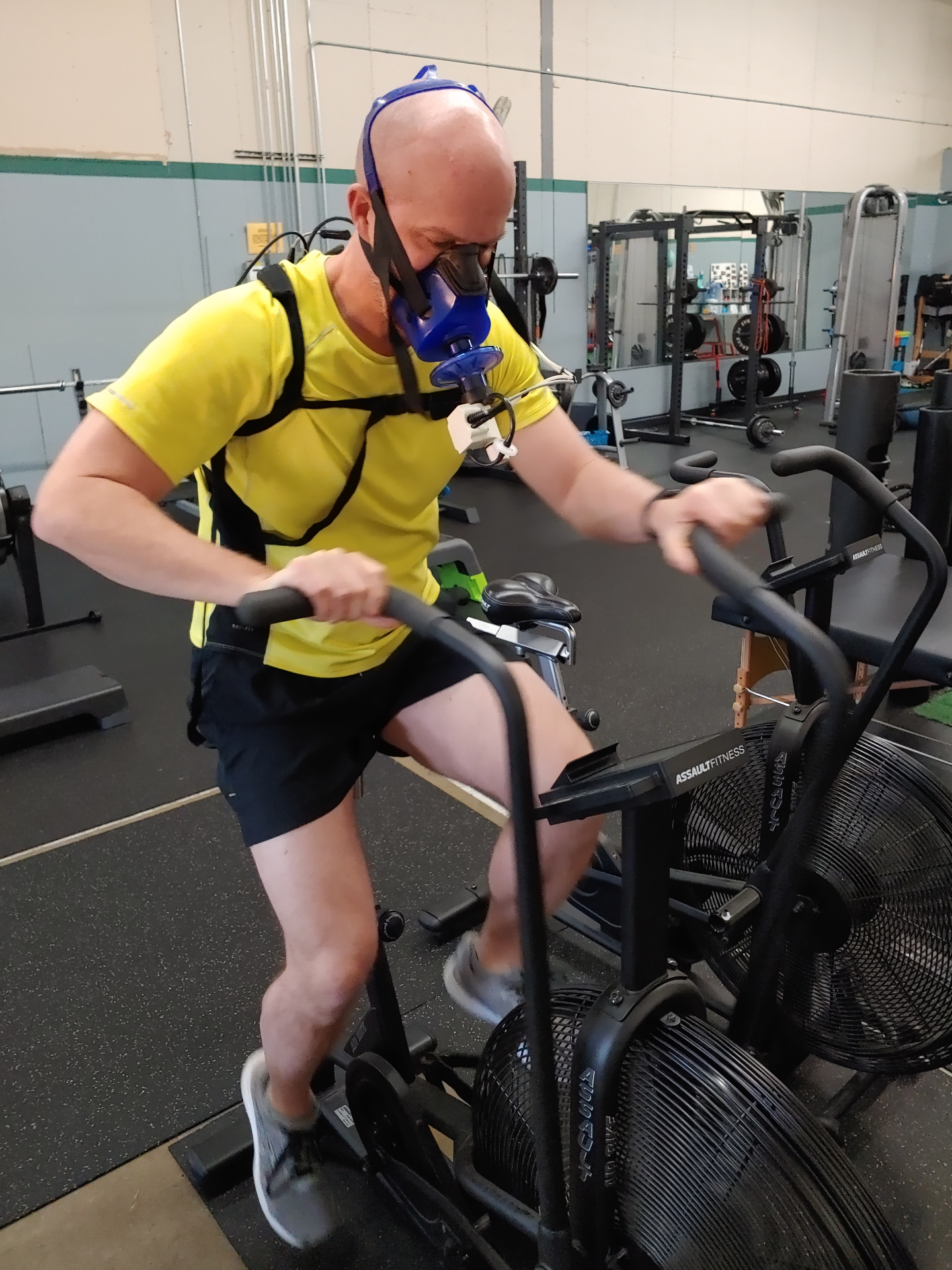 Member performing a VO2 metabolic test on an air bike with a respiratory mask