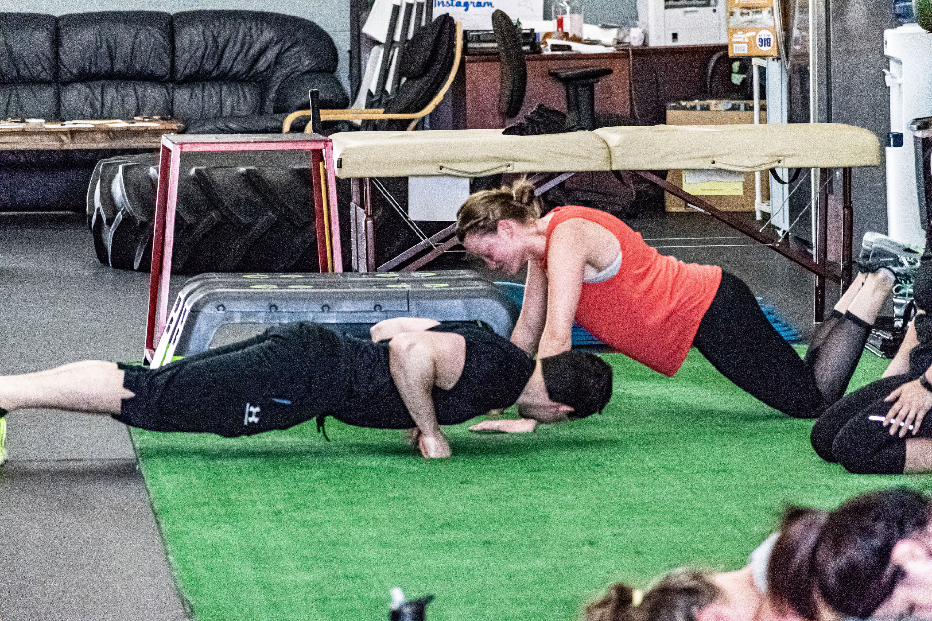 Personal trainer coaching a client through a floor exercise