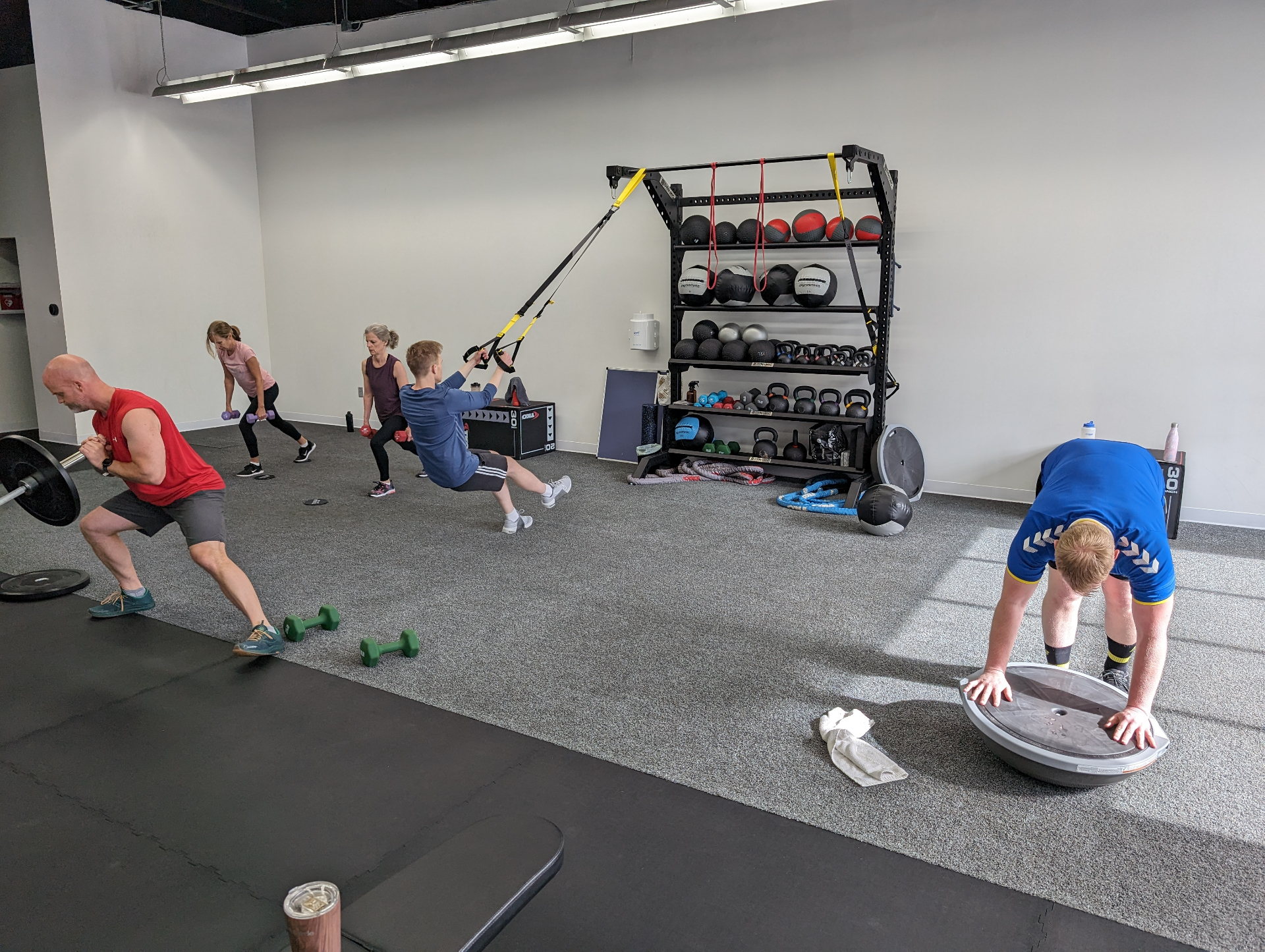 Envision Fitness members during a bootcamp squat circuit in the studio